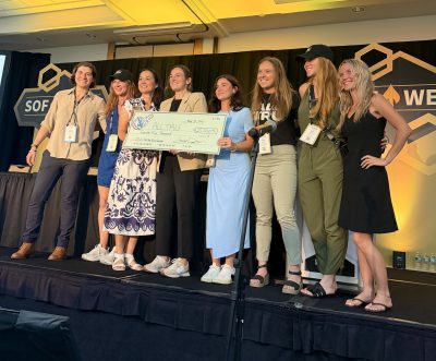 Representatives of ALLTRU hold a ceremonial check after winning first place in the SOF Week 2026 Non-Profit Round Robin.