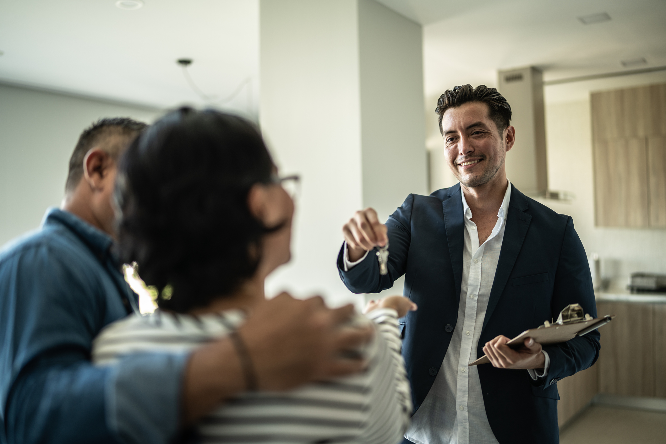 Real estate agent giving the home keys to a costumer at home