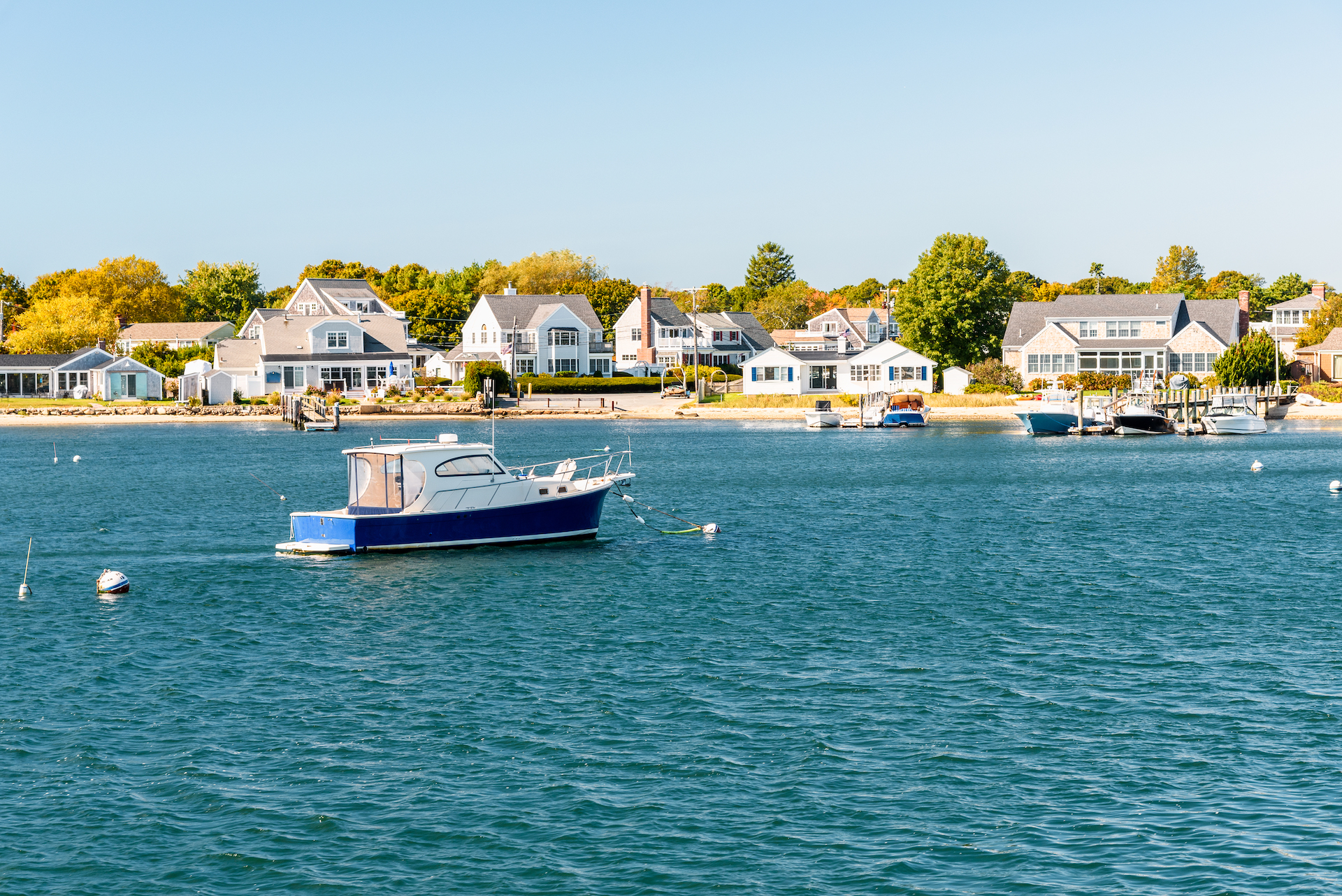 Motorboat moored off a built up coast on a sunny autumn day