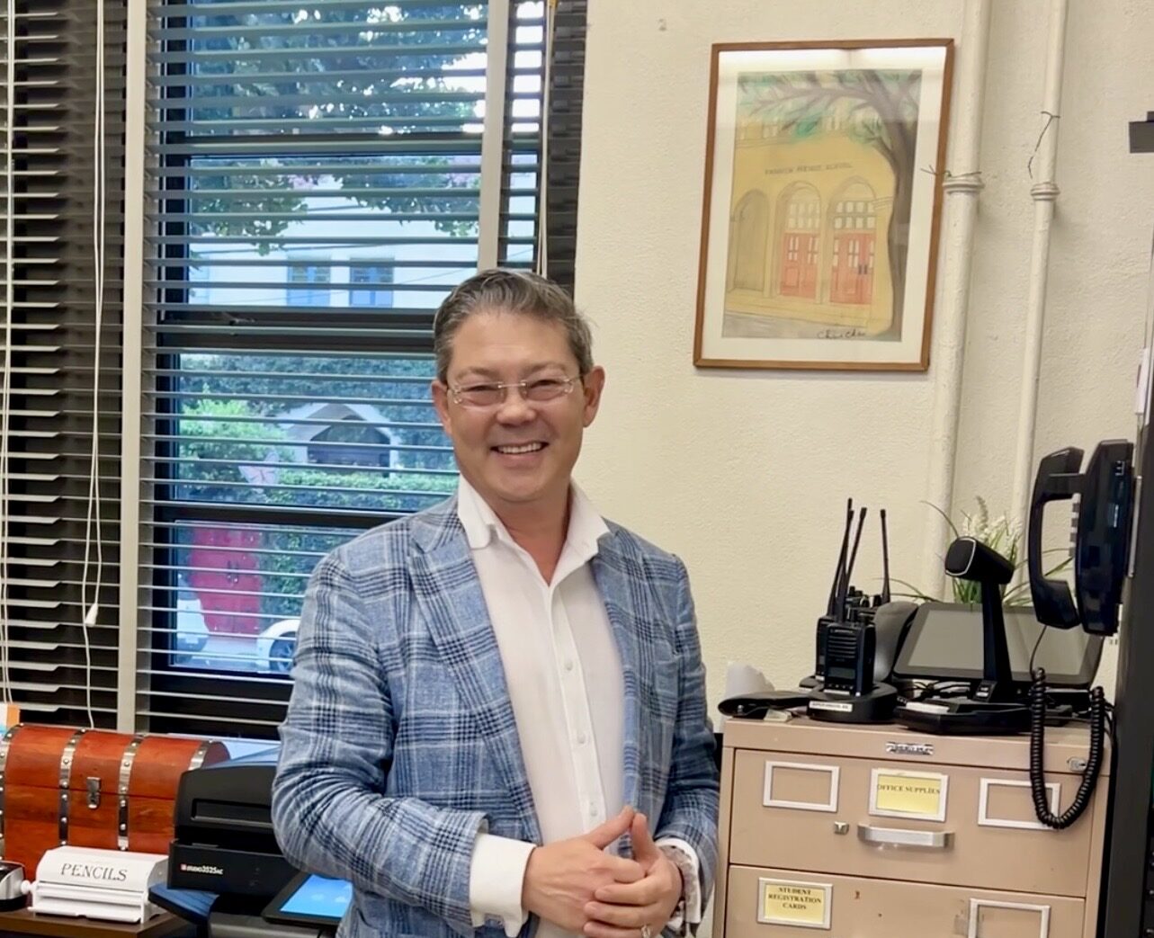 Christophe Choo top Beverly Hills real estate agent standing in front of his childhood pastel artwork at Franklin Avenue Elementary School in Los Feliz Los Angeles