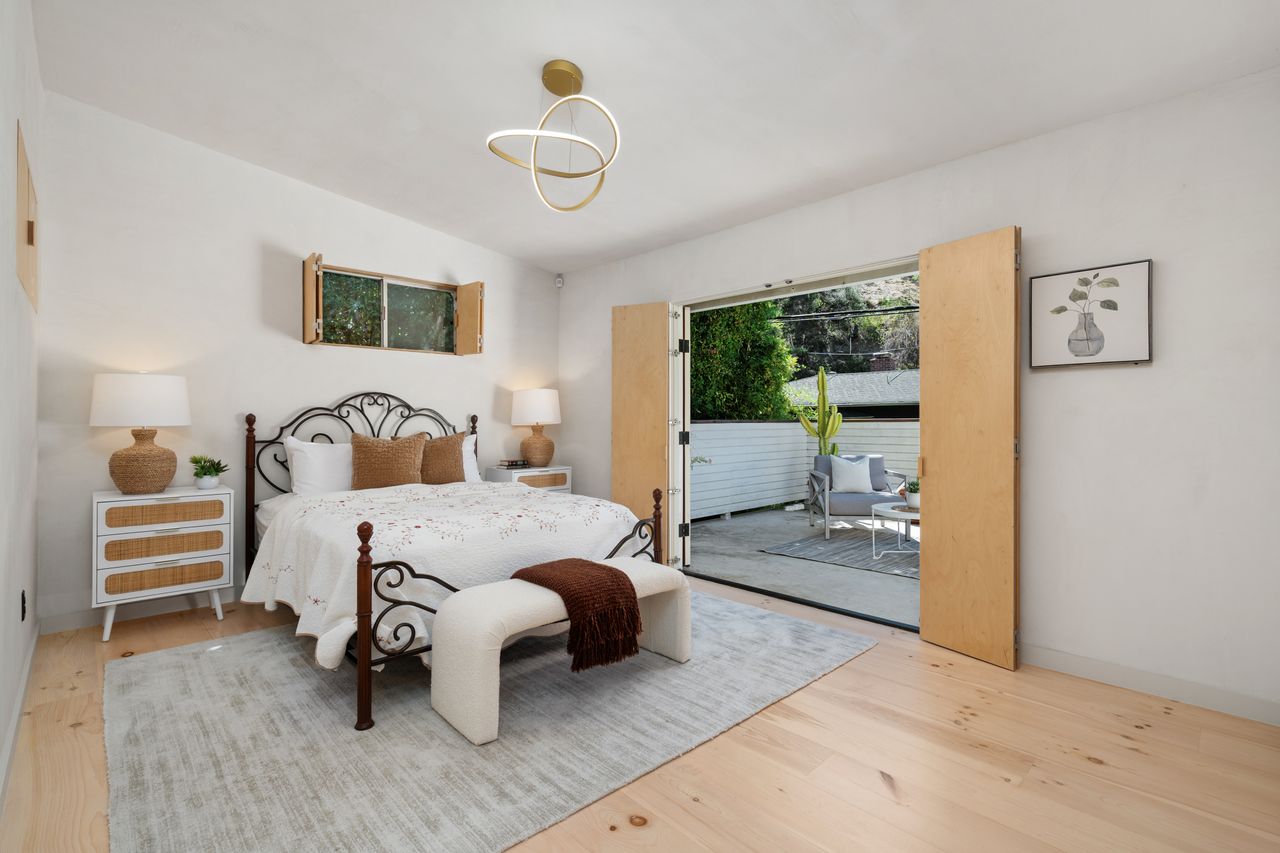 Primary suite bedroom featuring organic plaster walls, custom pine floors, and custom-milled birchwood window panels.