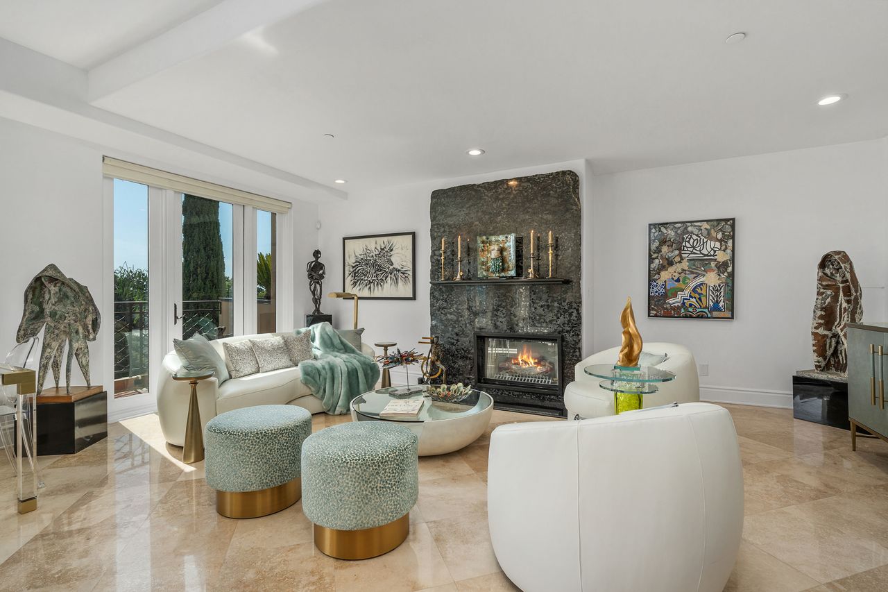 Formal living room featuring custom marble fireplace and French doors at 137 S Spalding Dr #401 Beverly Hills
