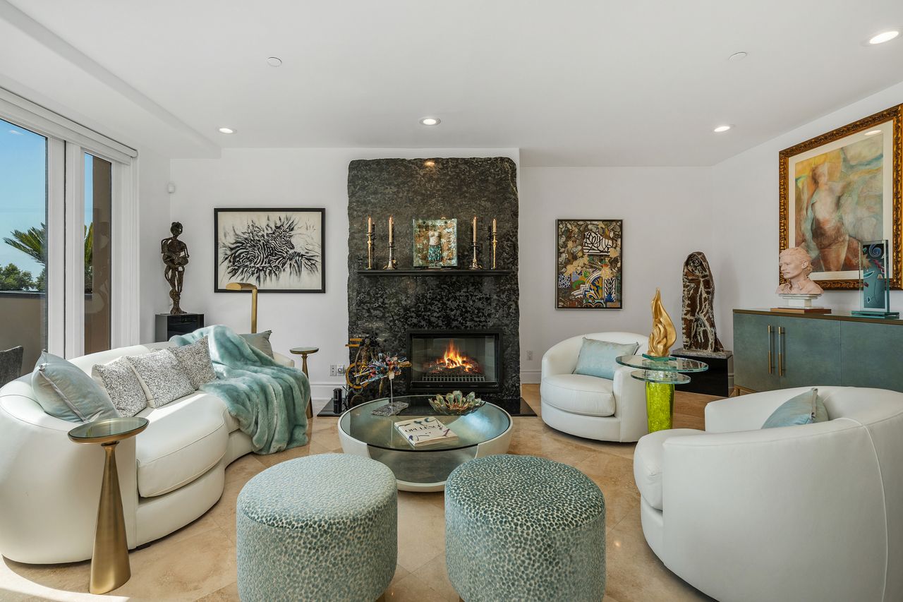 Modern formal living room with two-slab black marble fireplace and French doors at 137 S Spalding Dr #401 Beverly Hills