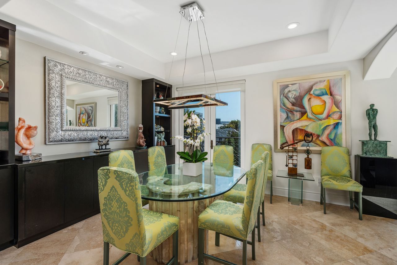 Formal dining room with glass table and modern chandelier at 137 S Spalding Dr #401 Beverly Hills