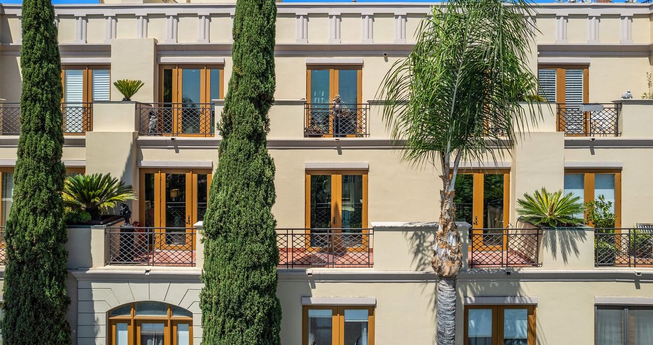 Exterior Mediterranean building facade showing double level penthouse balconies at 137 S Spalding Dr #401 Beverly Hills
