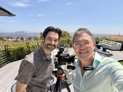 Top luxury real estate agent filming on set with photographer David overlooking the Hollywood Hills skyline at 1501 Viewsite Dr, Los Angeles.