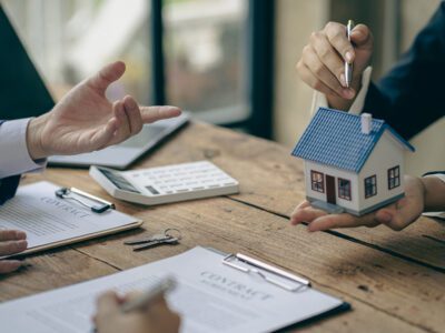 real estate agent discussing holding a miniature house