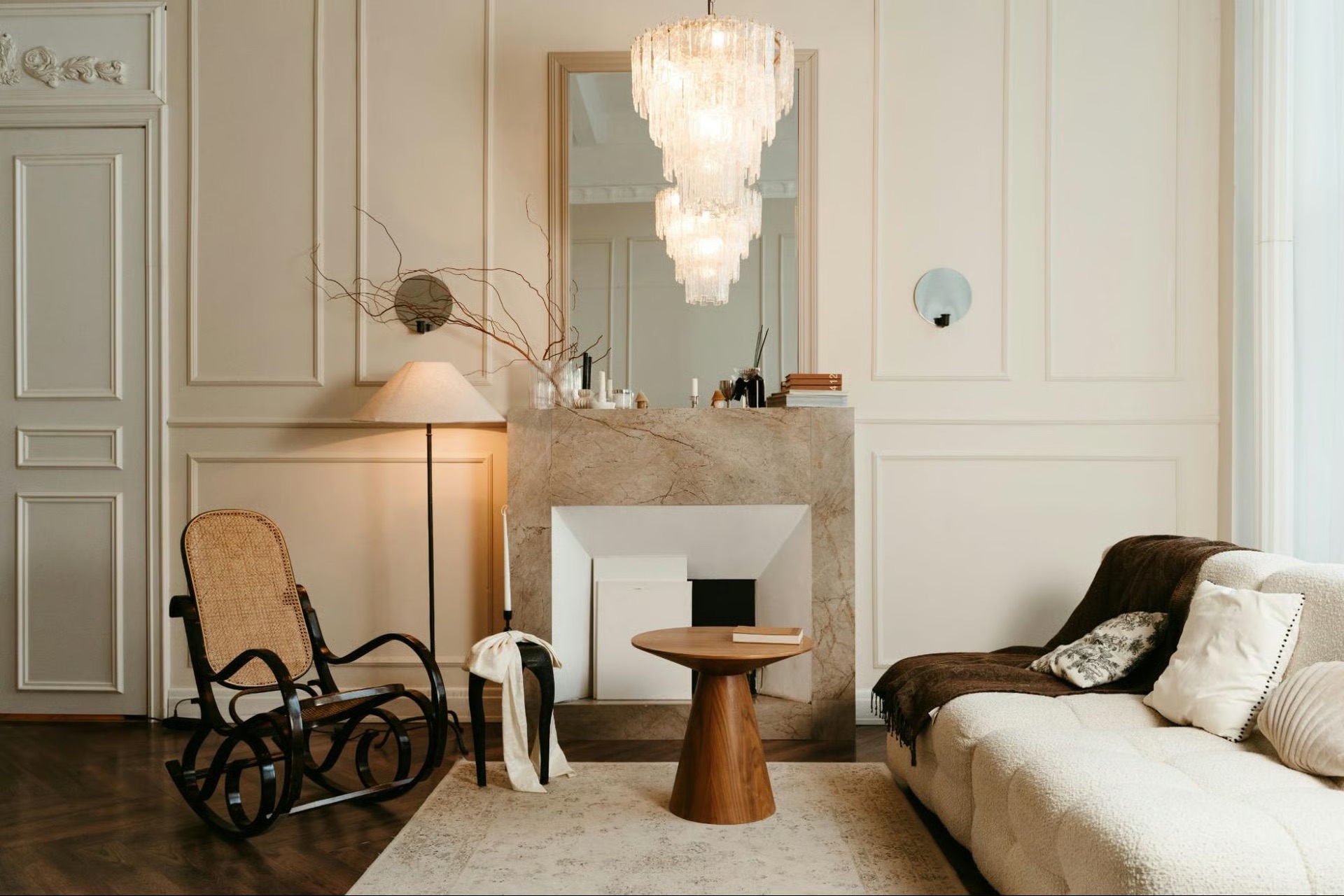 Chandelier over a marble fireplace and side table