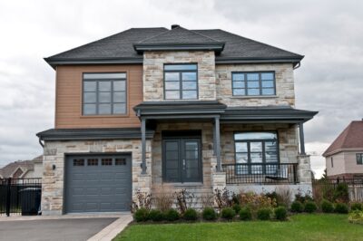 A modern two-story single-family home with a stone exterior and attached garage, reflecting the newer construction style commonly found in Woodbury neighborhoods.