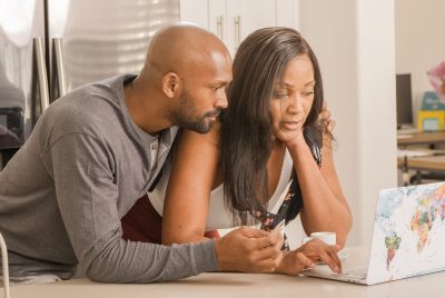 Couple reviewing online home listings together, illustrating how buyers use MLS-powered property information to research homes and make informed decisions.