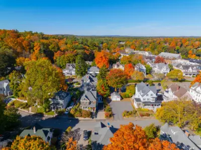 Aerial view of historic Wellesley MA neighborhood with Victorian and Colonial homes among fall foliage