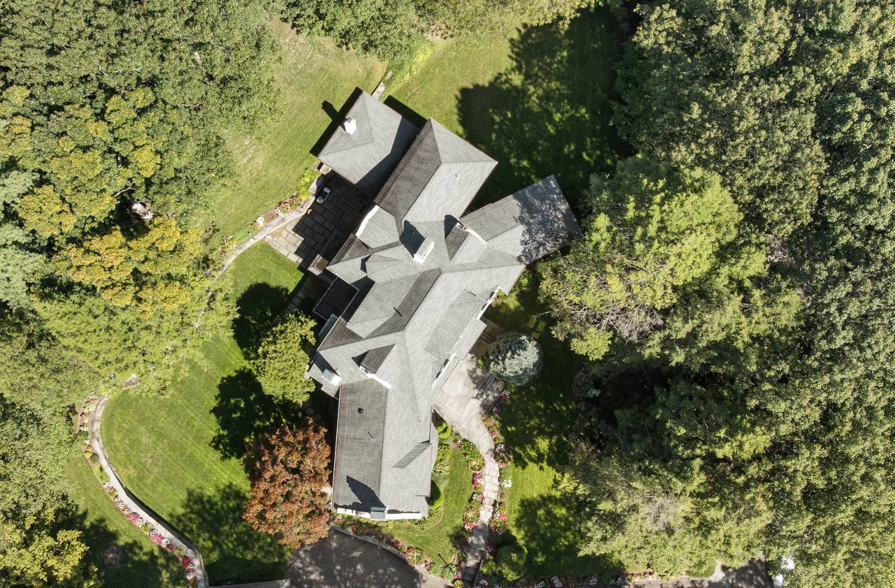 Aerial view of a Chestnut Hill property showing the mature trees and gardens typical of luxury homes in Brookline MA