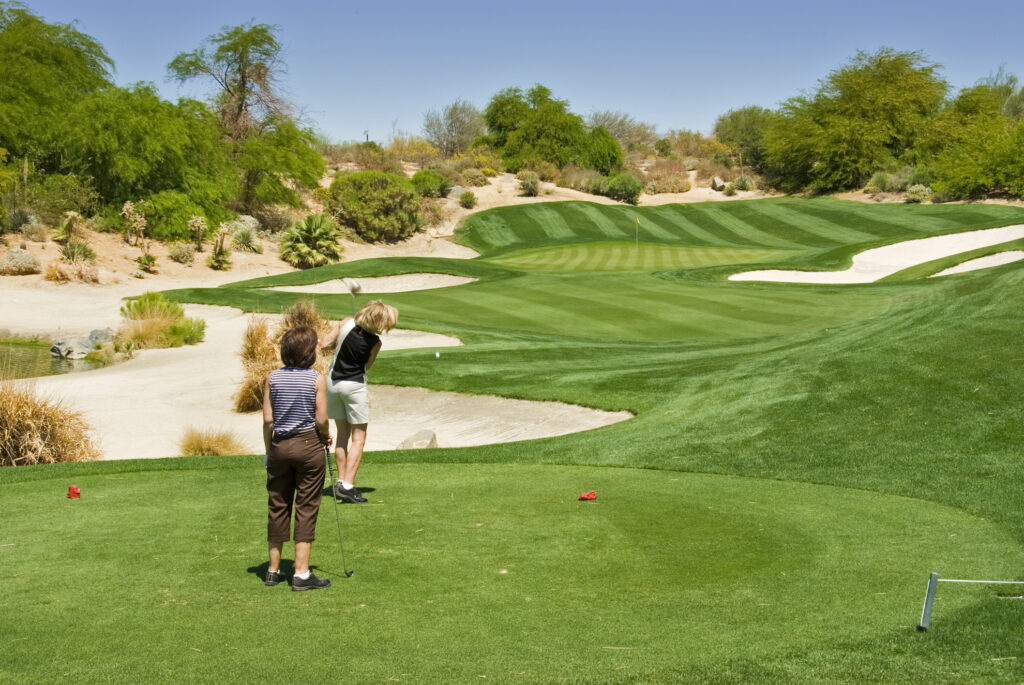 Two women playing golf