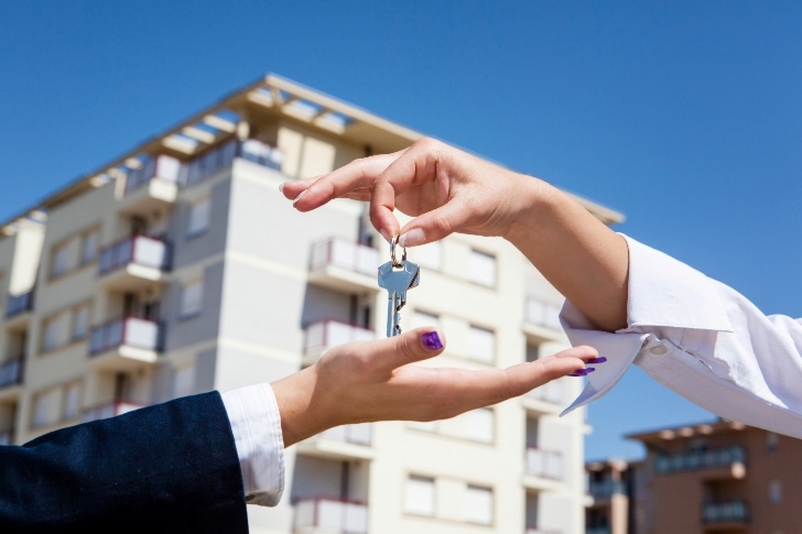 real estate agent passing the key to the client