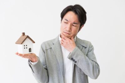 a man holding a mini house model