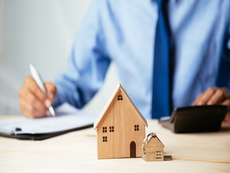 Man writing and a model house
