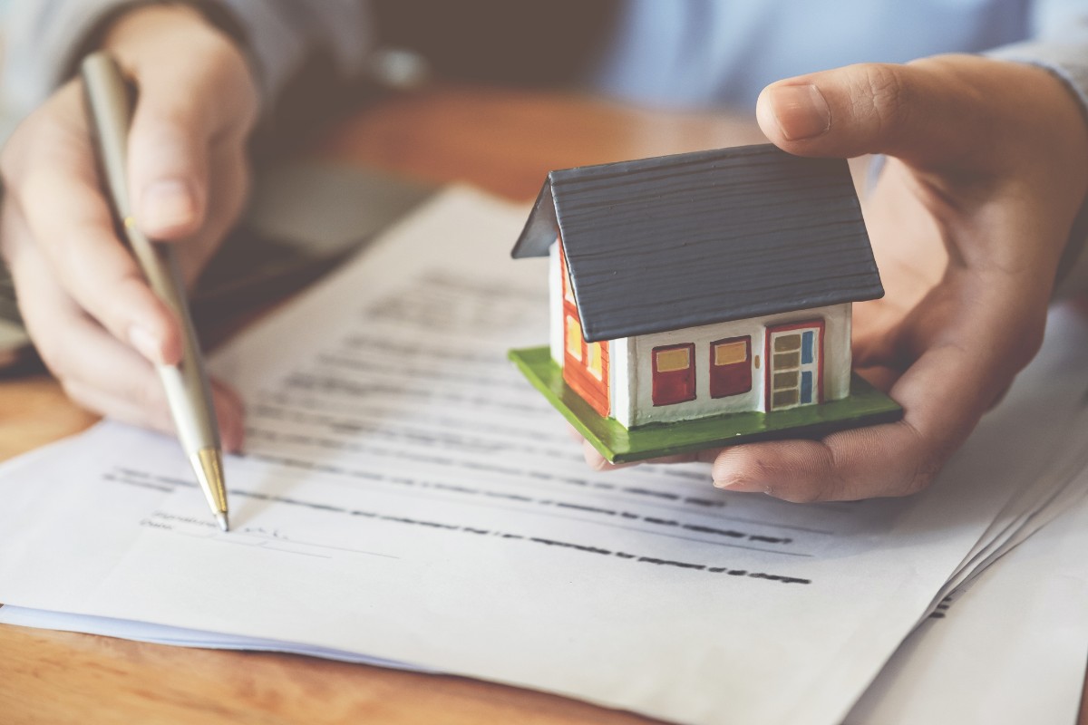 man holding miniature house