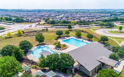 Blanco Vista subdivision pool and park in San Marcos TX featuring resort-style swimming pool, playground, and community green space.