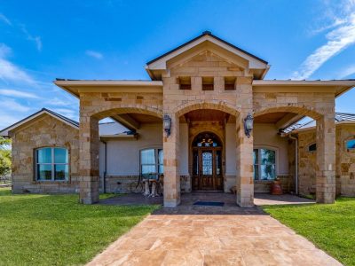 Texas Hill Country estate San Marcos TX front entry at 761 Allison Lane with stone exterior, covered porch, and luxury architectural design
