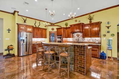 Texas Hill Country estate San Marcos TX kitchen with custom wood cabinets, granite island, and high-end finishes