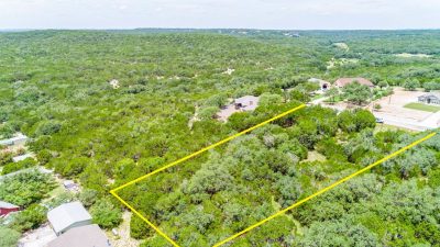 Aerial view of 239 George Strait in Fischer TX with boundary lines showing 1.26-acre Canyon Lake TX lot surrounded by mature trees and Hill Country terrain
