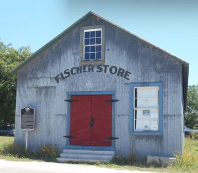 Historic Fischer Store in Fischer Texas featuring rustic metal exterior and red double doors, showcasing local Hill Country heritage