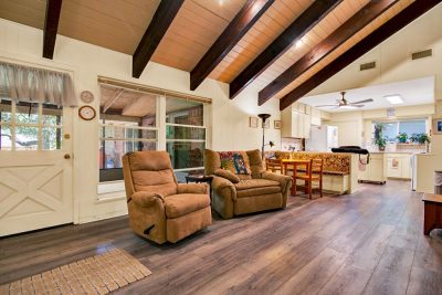 Family room with exposed wood beams and brick fireplace in established San Marcos residence