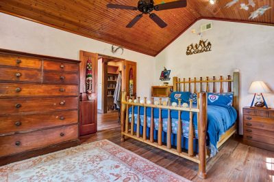 Private guest suite with vaulted wood ceiling, custom furnishings, and warm rustic finishes