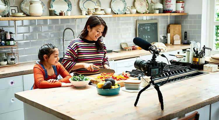 Daughter helping mother prepare healthy meal in kitchen