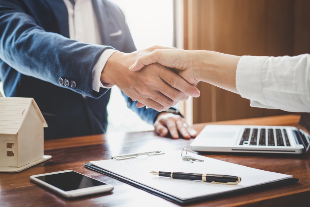 Real estate agent and customers shaking hands