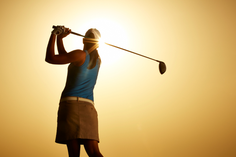 woman swinging golf club