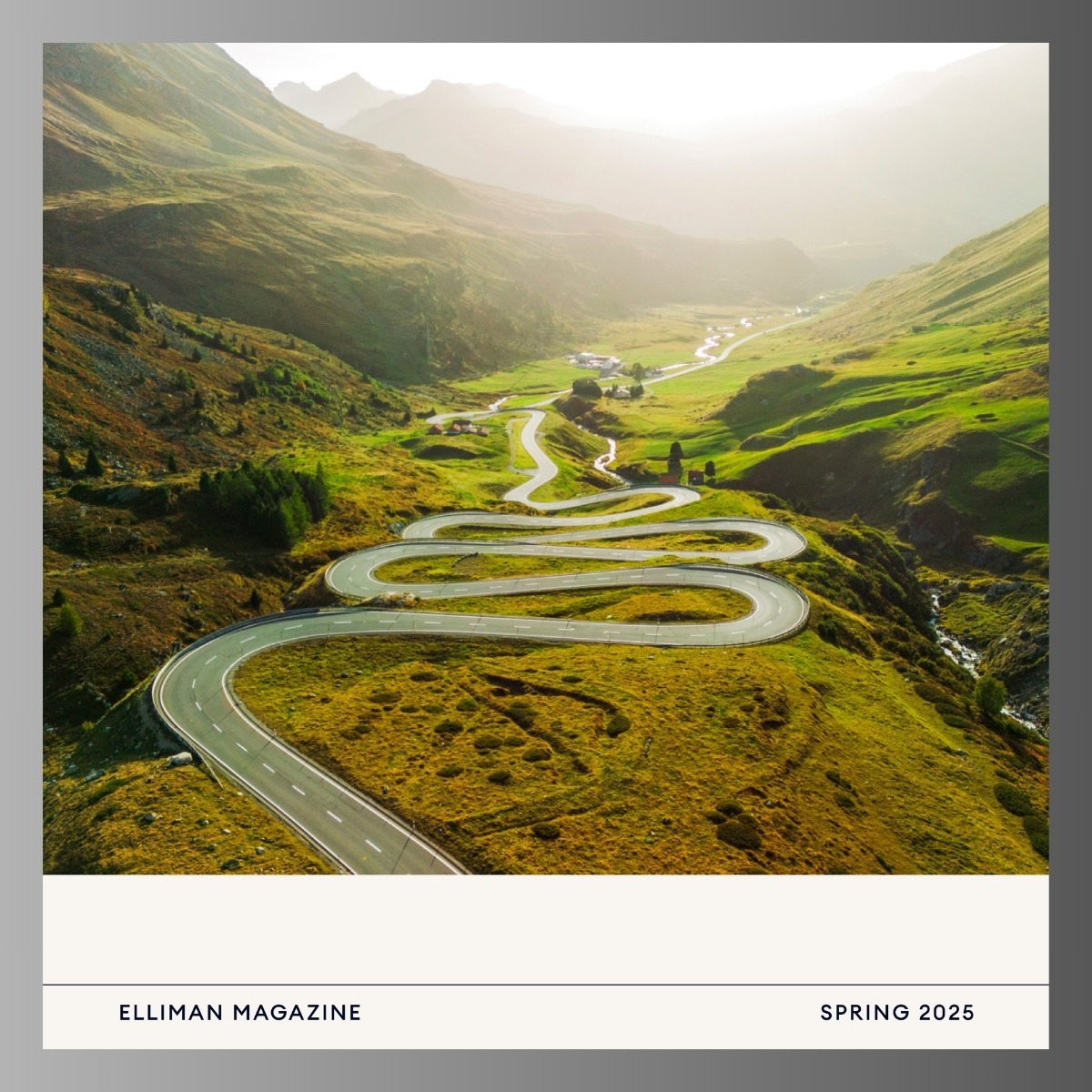 Winding mountain road with dramatic S-curves snaking through a lush green valley