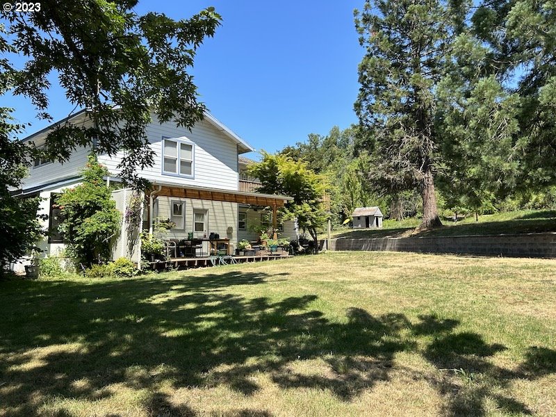 Home with a large backyard and mature trees on a spacious property in Damascus, Oregon.