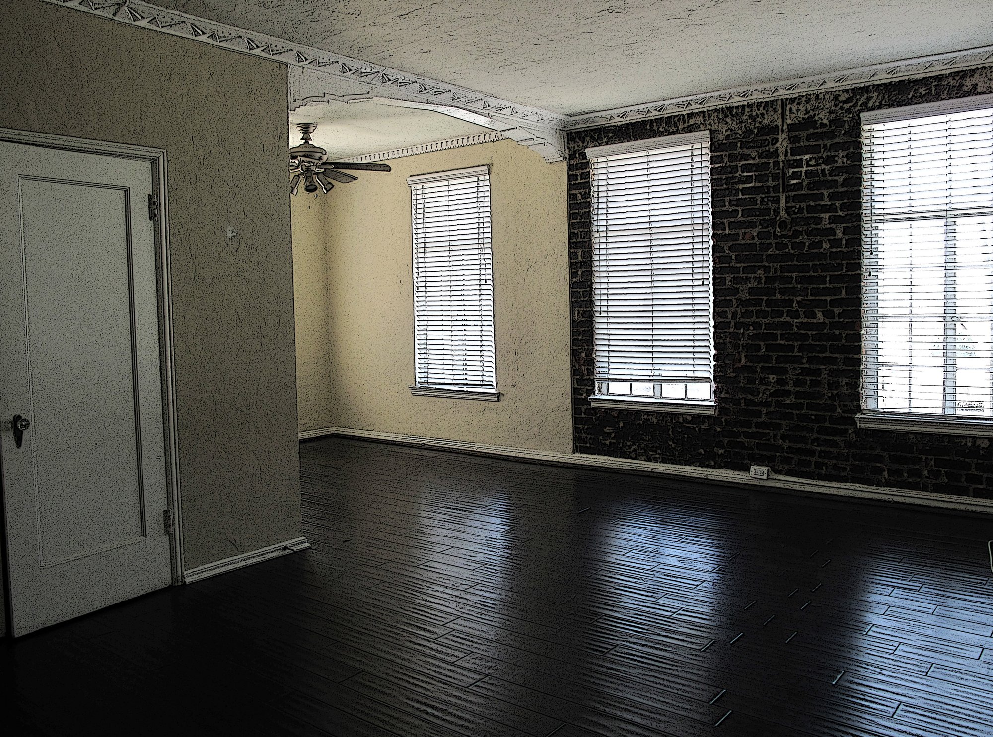 Empty living room with hardwood floors and exposed brick, prepared so you can sell my house fast in Queens