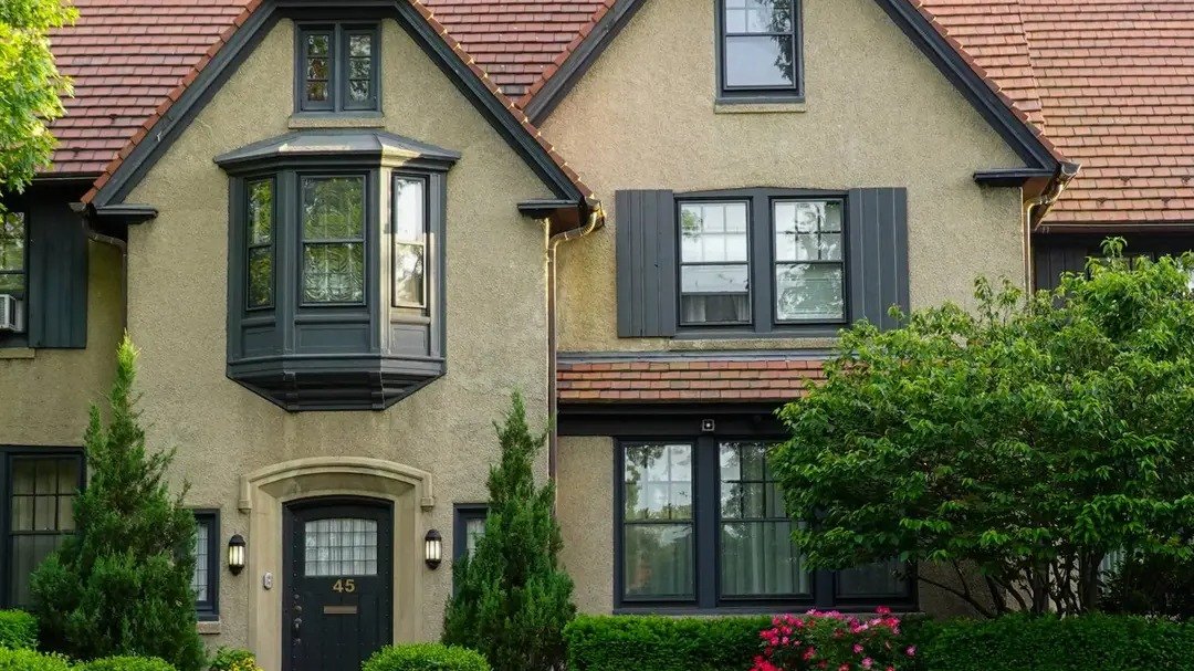 Casa renovada de estuco con techo de tejas y jardín frontal en Forest Hills, Queens, NY