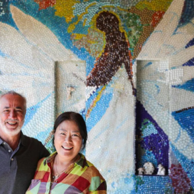mosaic wall in background with happy couple