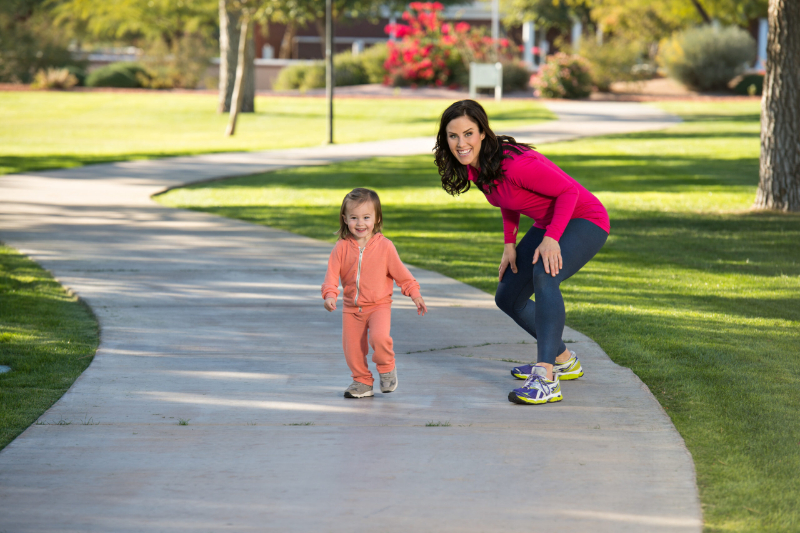 buy a home near a greenbelt, this is an image of Beautiful young mother and her daughter running in the neighborhood. They are on a sidewalk in a grassy greenbelt. The mother is playfully chasing her daughter. buy a home near a greenbelt, this is an image of Beautiful young mother and her daughter running in the neighborhood. They are on a sidewalk in a grassy greenbelt. The mother is playfully chasing her daughter.