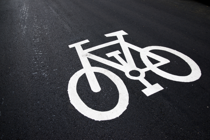 Bike lane sign painted on a street. to 