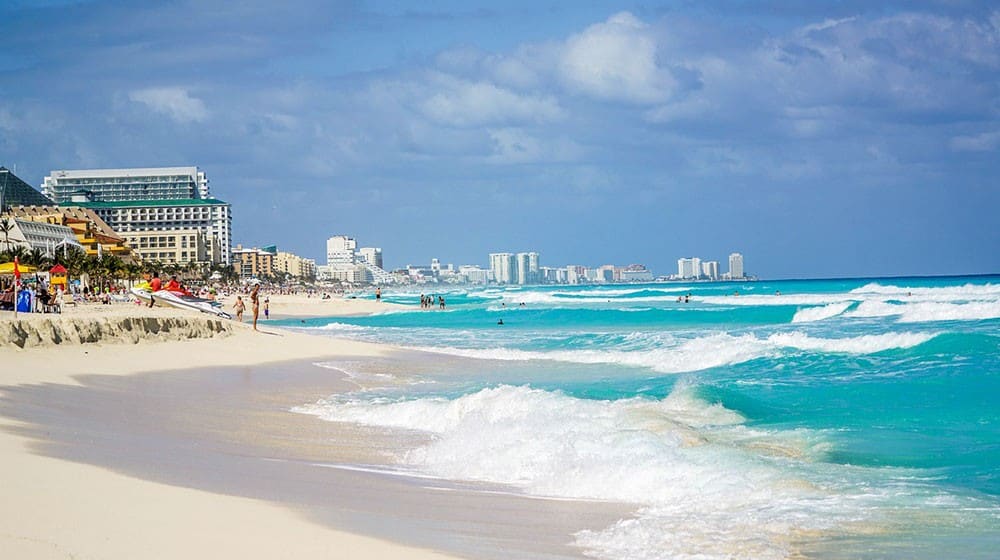 A high-end yacht docked at a private marina under the bright Cancun sun