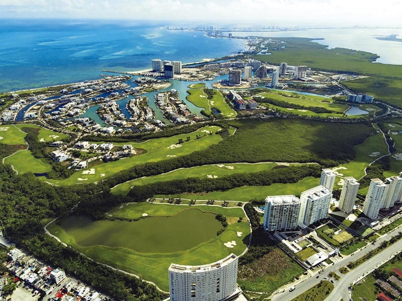 Panoramic view of luxury waterfront homes in Puerto Cancun residential marina.