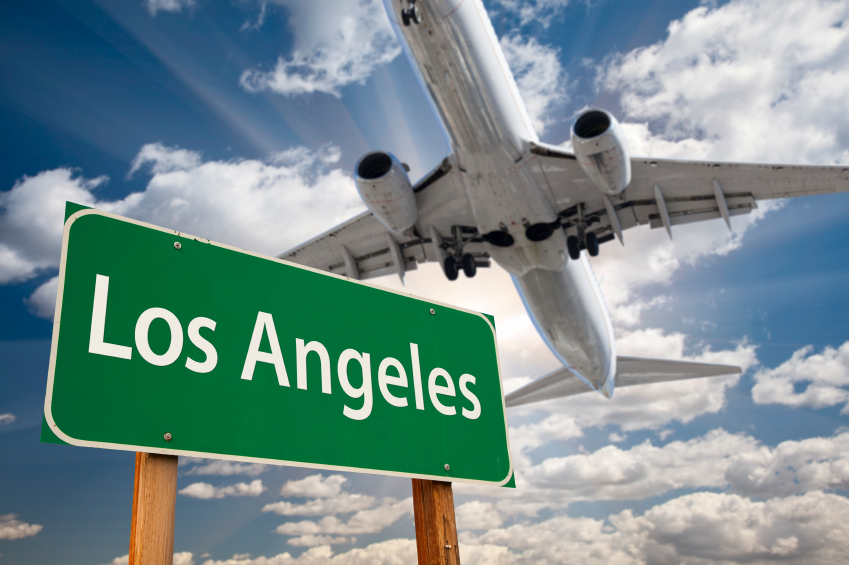 Los Angeles Green Road Sign and Airplane Above with Dramatic Blue Sky and Clouds.
