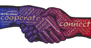 Image is an illustration of two hands shaking with words like "cooperation" and "connect" written inside of them.