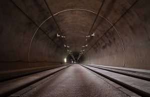 Image is the inside of a concrete tunnel used for trains.