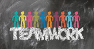 Image is a chalkboard drawn of colorful people on top of the word Teamwork. Image is a chalkboard drawn of colorful people on top of the word Teamwork.