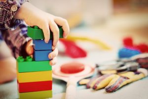 Image is of a young child playing with blocks.