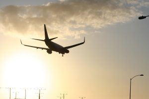 Image is an airplane landing at LAX at dusk.