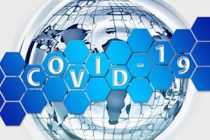 Image is a drawing of the earth with the word COVID-19 superimposed over it.