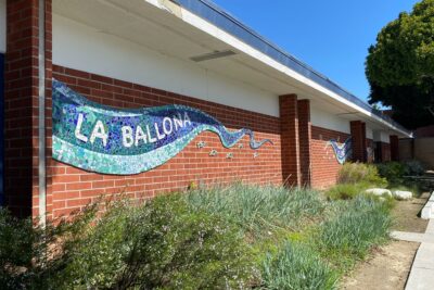 Culver City Unified School District's La Ballona Elementary school is pictured here. There is a blue mural with the school's name, the image is sourced from wikimedia.