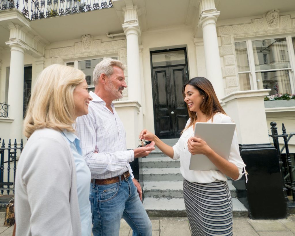 A sellers' agent hands over the keys to new buyers.