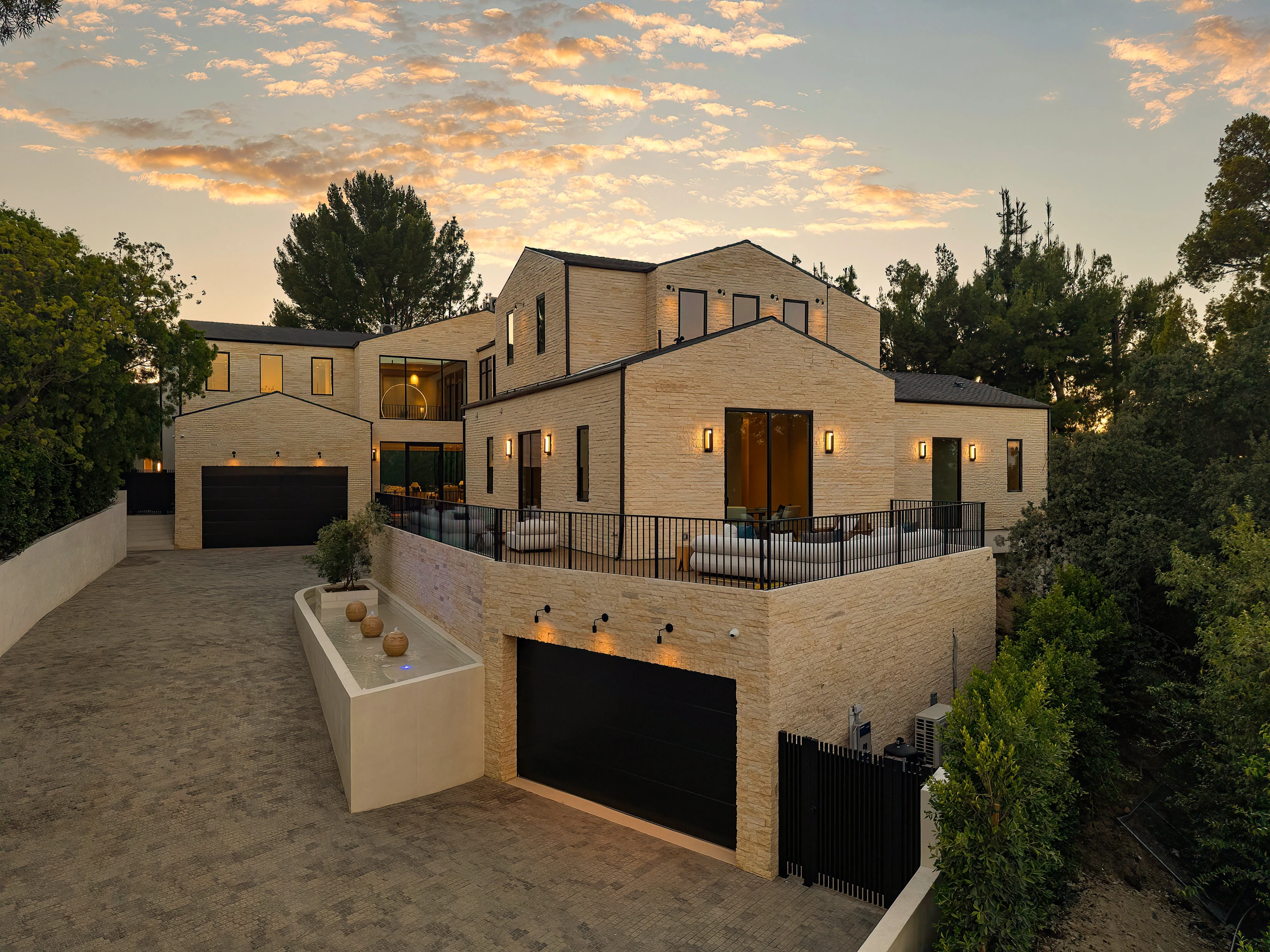 The gated arrival and stone-clad front elevation